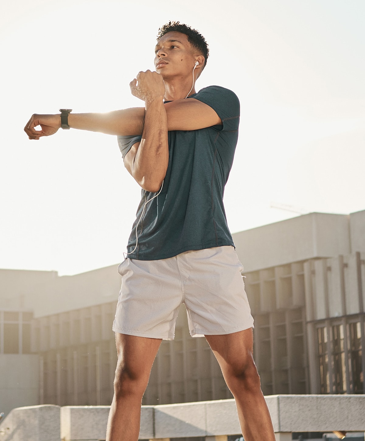 NYC Pilonidal Cyst Treatment man stretching outdoors with earbuds on.