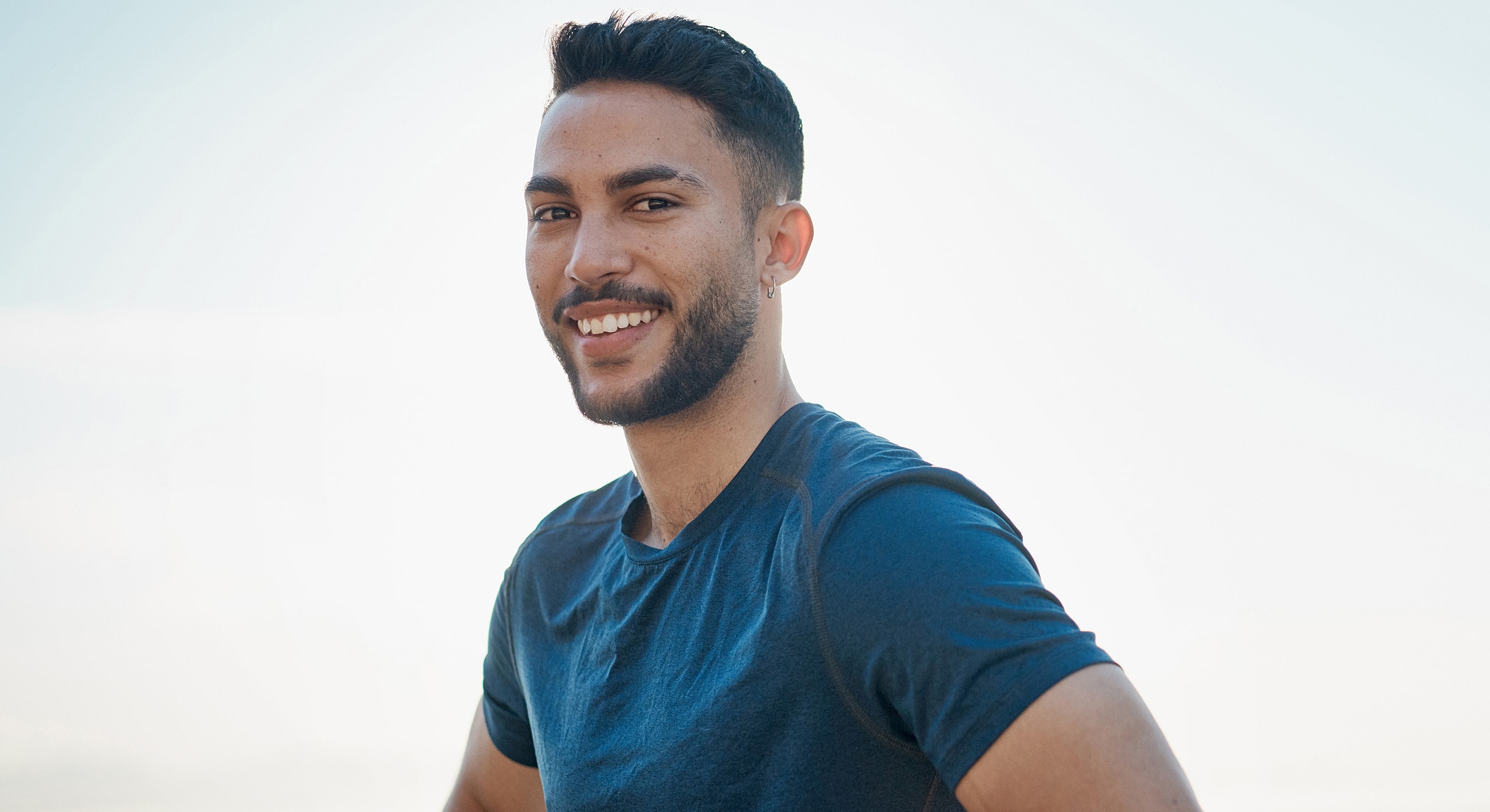 Smiling man in a casual blue shirt.